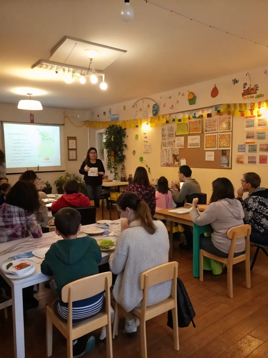 A diverse group of families attending a seminar on effective parenting techniques, set in a modern and welcoming community hall.